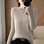 Cozy beige ribbed pullover with a crewneck and long sleeves, styled with black pants and gold accessories.