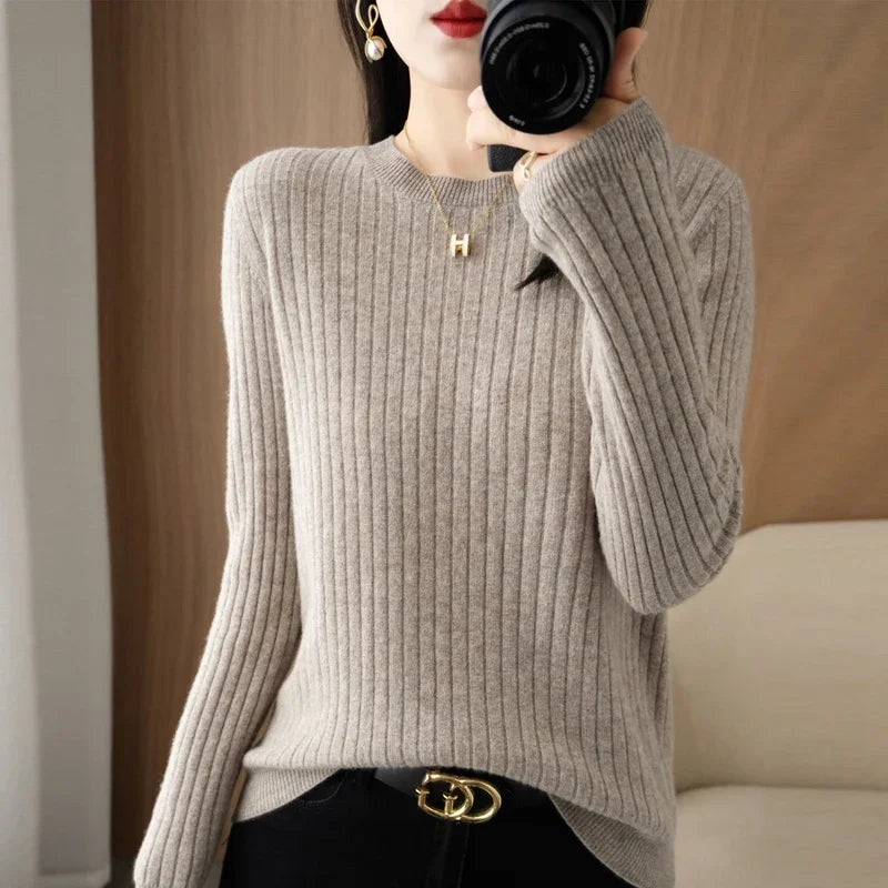 Cozy beige ribbed pullover with a crewneck and long sleeves, styled with black pants and gold accessories.