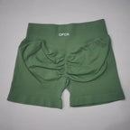 High-waisted, seamless gym shorts in a deep green color with a scrunch-butt design and wide waistband for support.