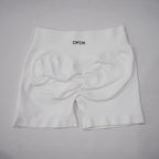 White high-waisted seamless gym shorts featuring a scrunch-butt design and an elastic waistband.