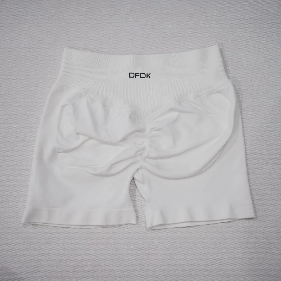 White high-waisted seamless gym shorts featuring a scrunch-butt design and an elastic waistband.