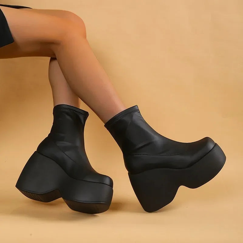 Ultra-chunky black eco-leather boots with a high platform and block heel, showcasing a sleek, sculpted silhouette.