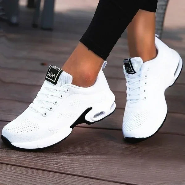 White LOVORA™ Aura Air Boost Platform Sneakers with a breathable mesh upper and black outsole, worn with black leggings.