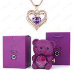 Luxury heart necklace set featuring a sparkling red heart pendant, a purple teddy bear, and a preserved rose in a gift box.