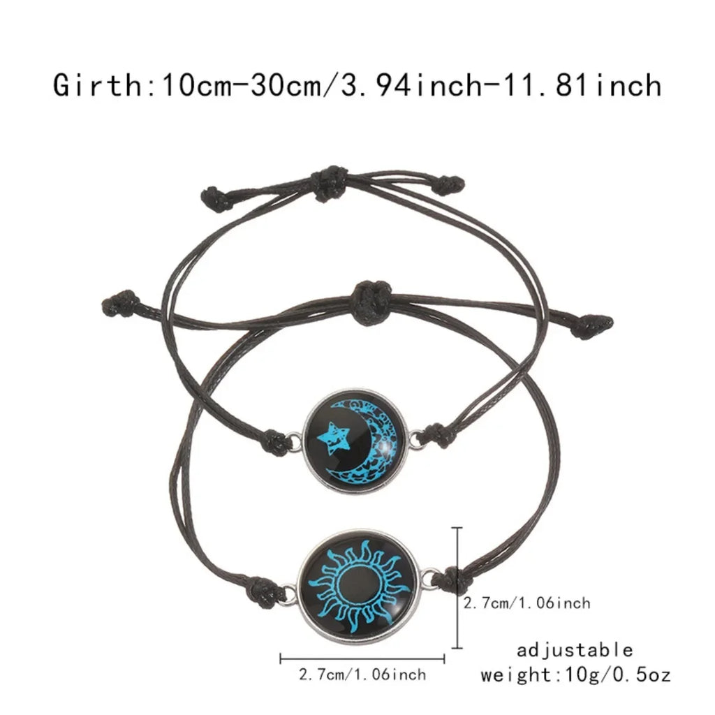 Two adjustable black rope bracelets featuring luminous Sun and Moon emblems with blue accents.