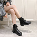 Croc-embossed chunky Chelsea boots in black, featuring lace-up detail and thick platform soles, model sitting cross-legged.