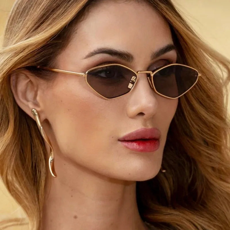 Polygonal metal sunglasses with diamond-cut lenses and gold metallic frame, worn by a model with wavy hair.