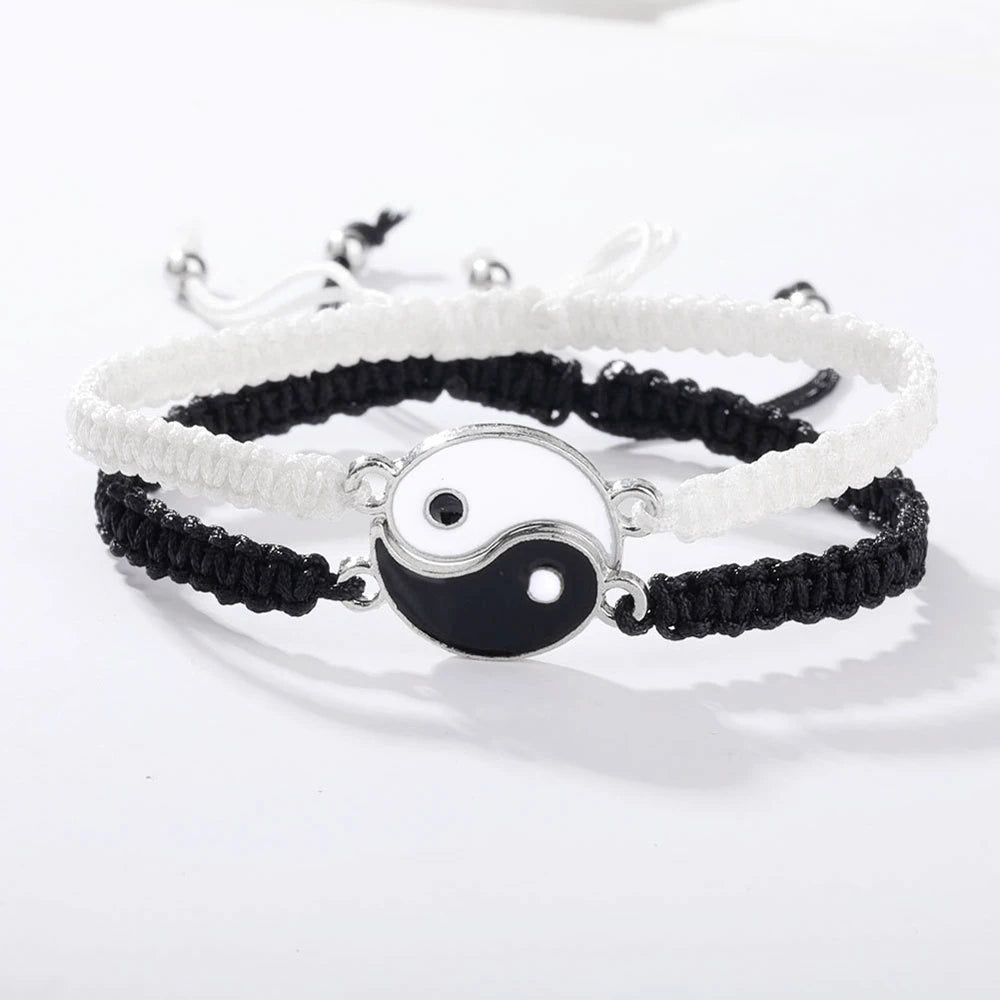 Yin Yang Braided Couple Bracelets in black and white, featuring interlocking enamel symbols on adjustable nylon cords.