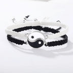 Yin Yang Braided Couple Bracelets in black and white, featuring interlocking enamel symbols on adjustable nylon cords.