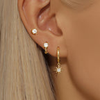 Asymmetric 3-piece earring set featuring gold-tone geometric hoops and star-shaped drops, worn in multiple piercings.