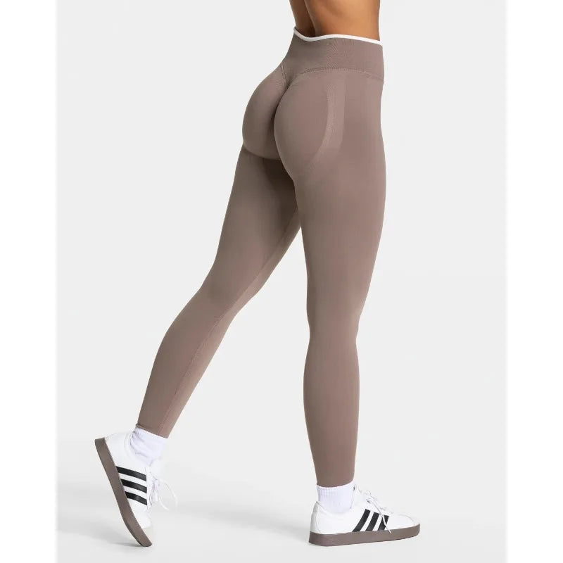 High-waisted, seamless leggings in a muted beige color with a supportive waistband and contrast paneling.
