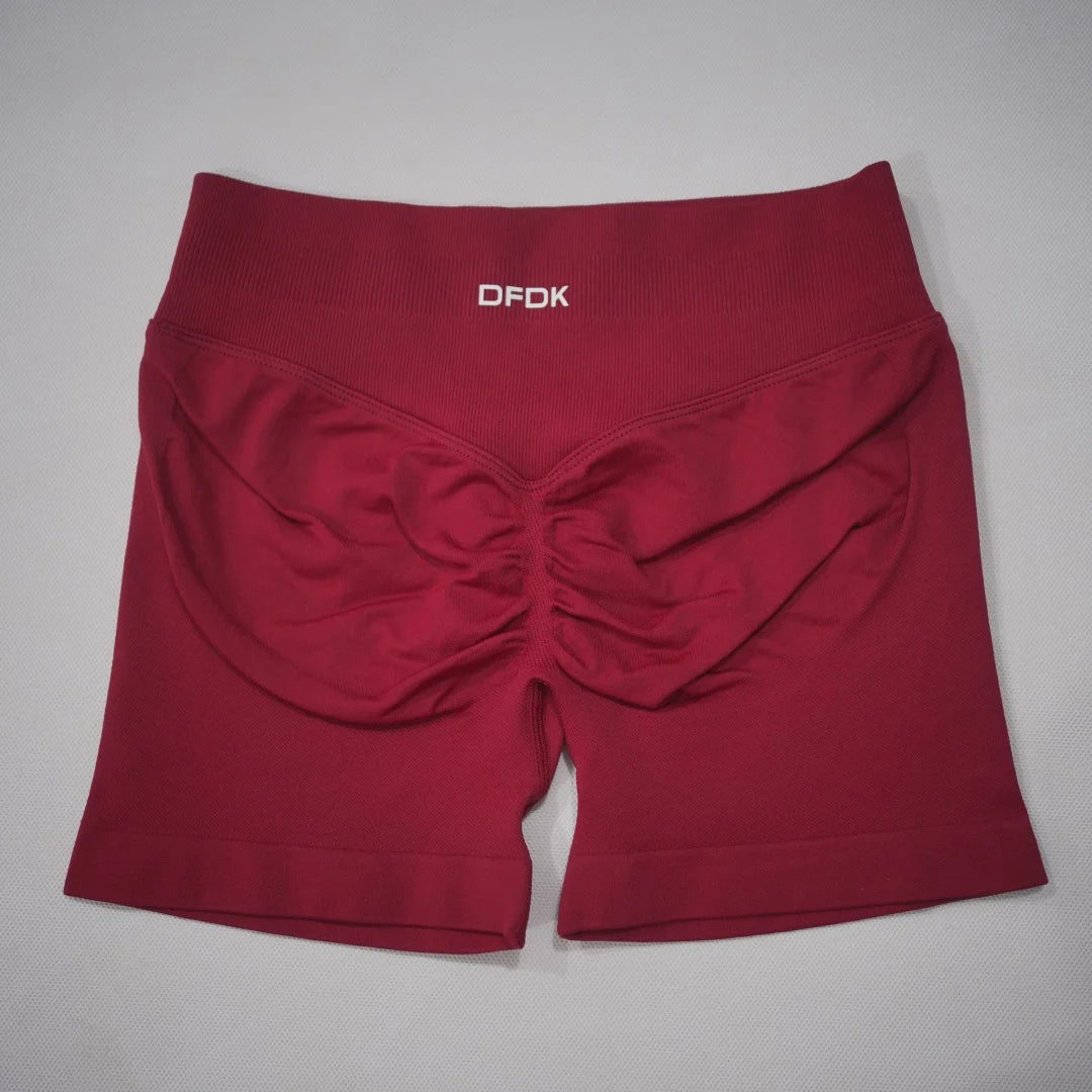 Burgundy high-waisted gym shorts featuring a scrunch-butt design and seamless construction, ideal for athletic wear.