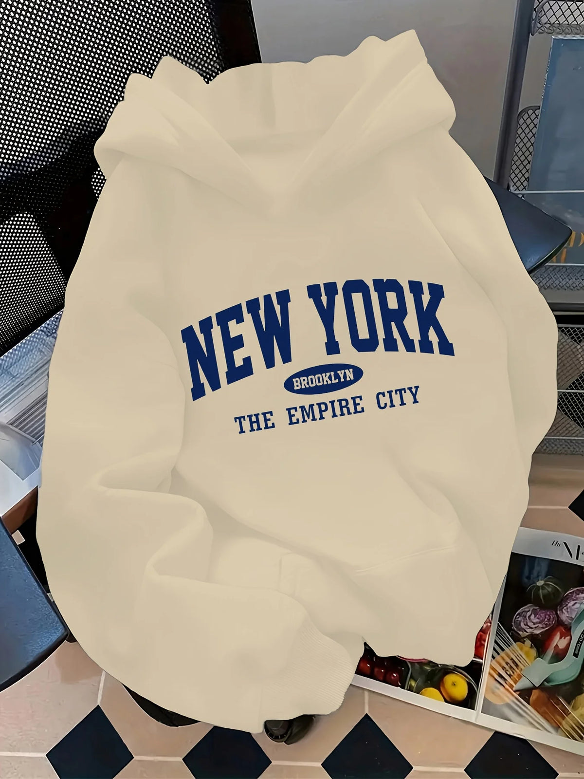Vintage oversized hoodie in cream with "NEW YORK BROOKLYN" graphic in navy blue, featuring a spacious hood and kangaroo pocket.