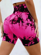 High-waisted gym shorts in vibrant pink tie-dye with a black pattern, offering a flattering scrunch detail for a lift effect.
