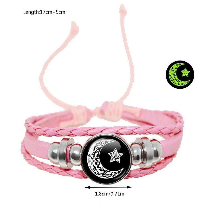 Multi-layered leather bracelet set featuring pink braided straps, black star-and-moon tokens, and silver-tone accents.