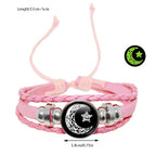 Multi-layered leather bracelet set featuring pink braided straps, black star-and-moon tokens, and silver-tone accents.