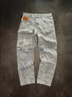 Light blue distressed denim jeans with oversized wide legs and detailed angel embroidery. Mid-rise waist and leather patch.