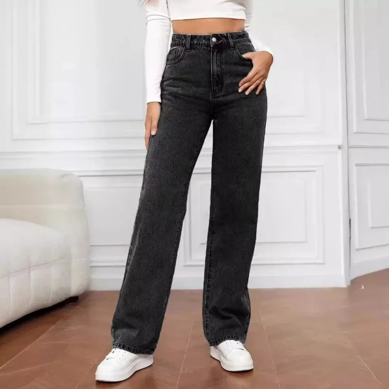 High-waisted, wide-leg jeans in a solid black wash, paired with a fitted white crop top and white sneakers.