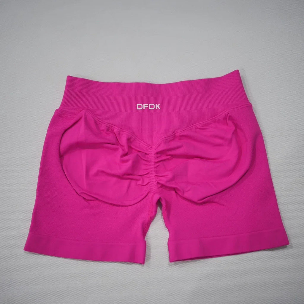Pink seamless high-waisted gym shorts featuring a scrunch-butt design and wide waistband for comfortable fit.