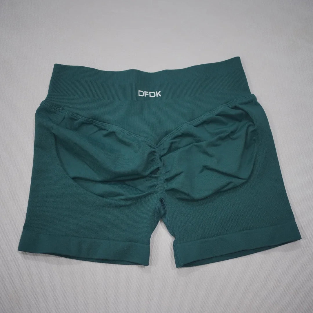 High-waisted teal gym shorts with a seamless design and scrunch butt detail, featuring a wide waistband for comfort.
