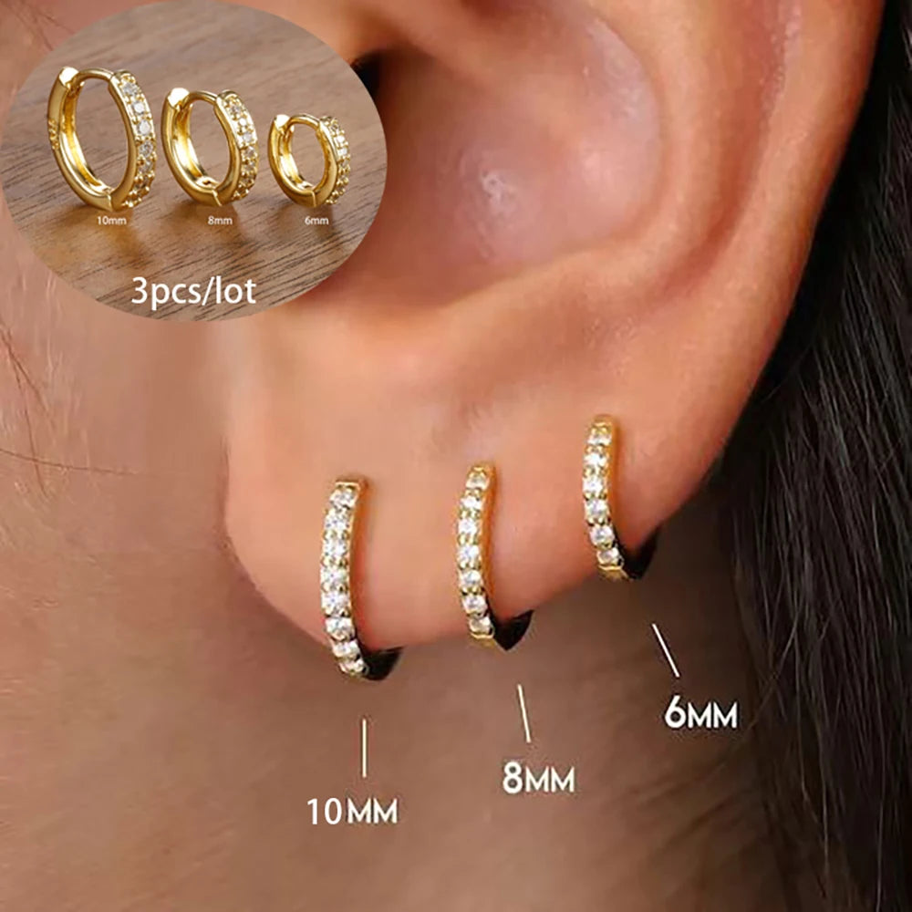Three gold geometric hoop earrings in various sizes (6mm, 8mm, 10mm) with sparkling embellishments displayed on an ear.