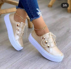 Classic leather platform sneakers in gold with a white sole, featuring decorative gold buttons and stylish laces.