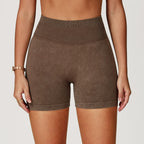 High-waisted, seamless gym shorts in a soft brown sand-washed texture, featuring a wide waistband and snug fit.