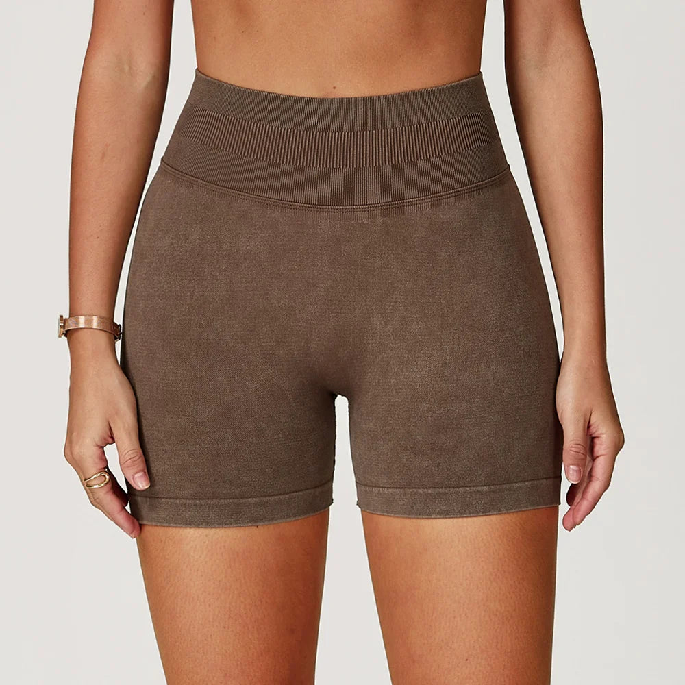High-waisted, seamless gym shorts in a soft brown sand-washed texture, featuring a wide waistband and snug fit.
