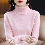Light pink turtleneck sweater with a relaxed fit, ribbed collar, and long sleeves, showcasing a soft, luxurious knit texture.