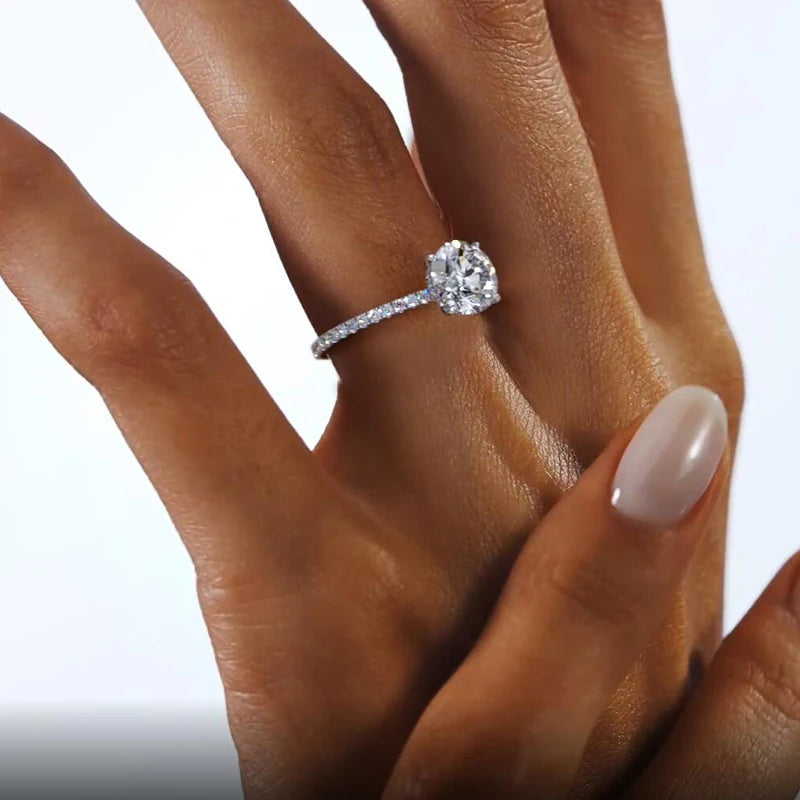The LOVORA™ Eternal 6-Prong Moissanite Solitaire Ring features a 2-carat round-cut gemstone set in a gleaming sterling silver band.