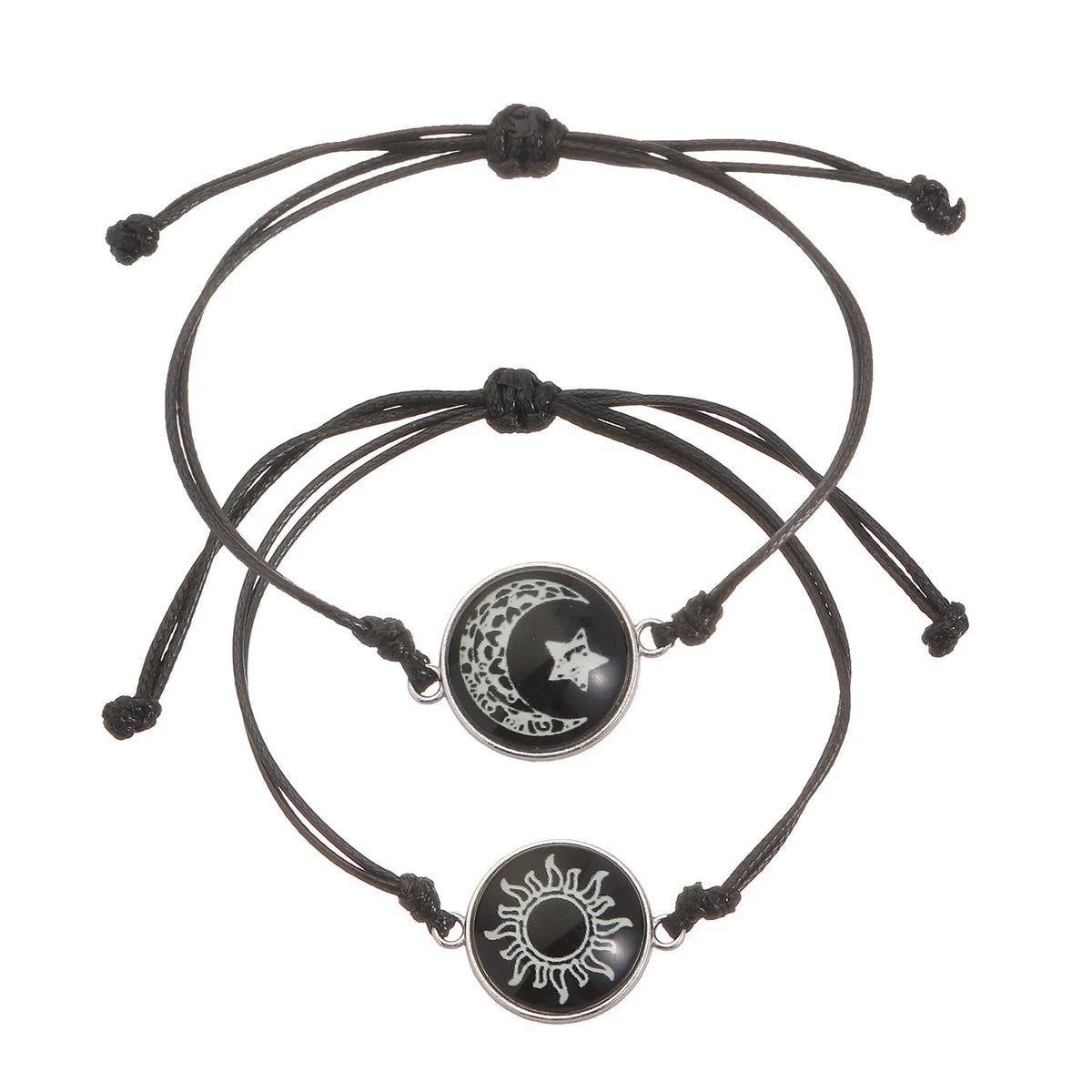 Two black rope bracelets featuring round charms: one with a moon and star design, the other with a sun emblem.