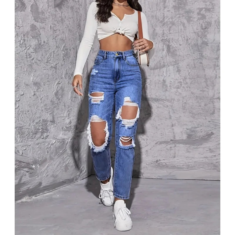 High-waisted distressed straight-leg denim jeans featuring ripped accents, worn with a cropped white top and white sneakers.