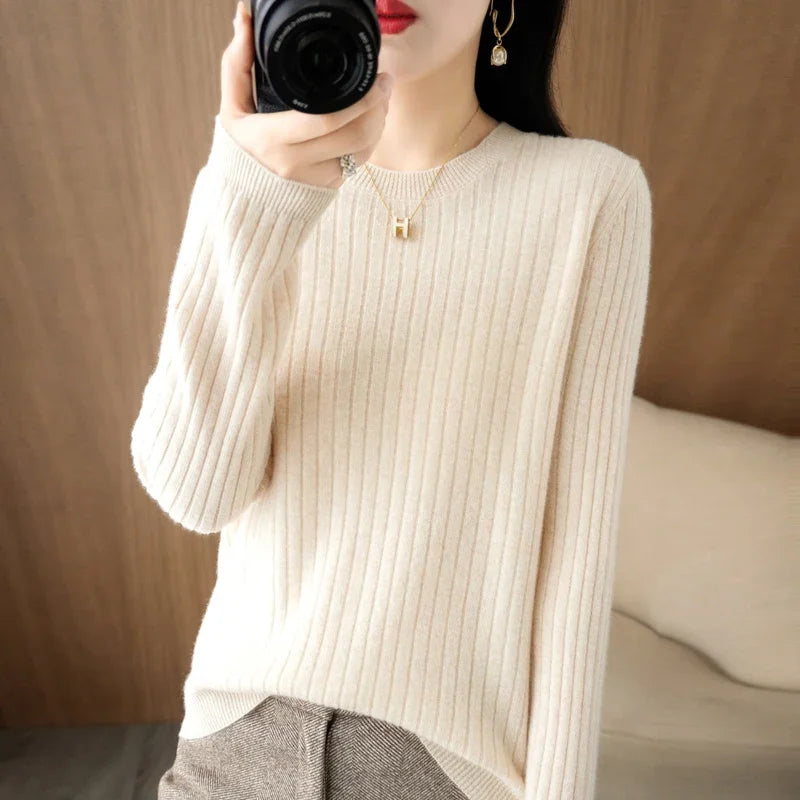 Cozy premium pullover in light cream with ribbed texture, featuring a crewneck and relaxed fit, styled with a pendant necklace.