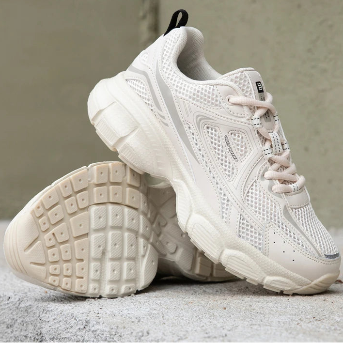 Chunky white and cream sneakers with a breathable mesh design, thick rubber sole, and unique tech-street style.