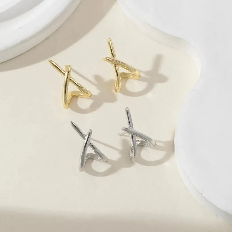 Minimalist cross stud earrings in gold and silver, showcasing a sleek, high-polish design and a lightweight fit.