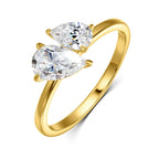 Gold ring featuring two pear-cut Moissanite gemstones, set in an asymmetric design with a smooth band.