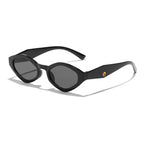 Bold cat-eye sunglasses with a thick black frame and dark lenses, featuring a stylish upswept silhouette.