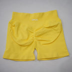 High-waisted gym shorts in bright yellow, featuring a scrunch-butt design and wide elastic waistband for support.