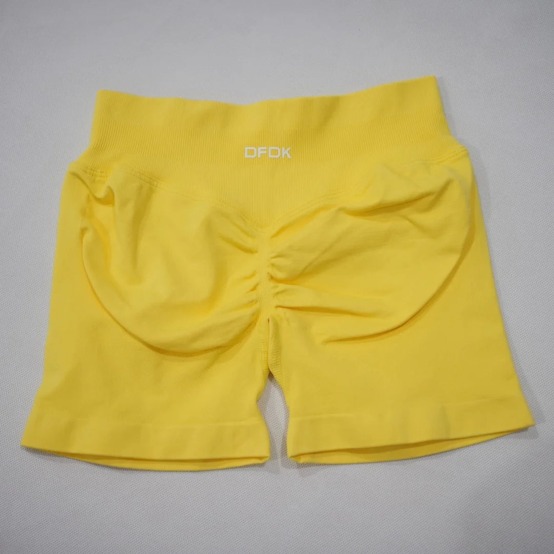 High-waisted gym shorts in bright yellow, featuring a scrunch-butt design and wide elastic waistband for support.