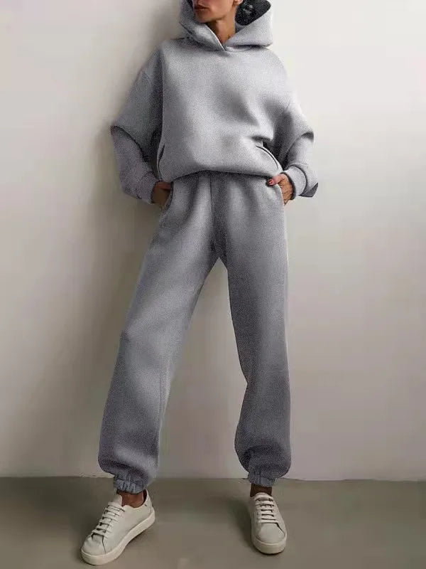High-waisted gray fleece tracksuit set featuring an oversized hoodie and jogger pants, worn with white sneakers.