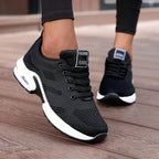 Black LOVORA™ Aura Air Boost Platform Sneakers featuring breathable mesh and a white platform sole, worn with black leggings.