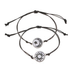 Two minimalist rope bracelets featuring a sun and moon emblem, designed with adjustable black cording.