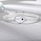 White braided bracelet featuring a Yin Yang enamel charm with a black dot, crafted from high-density nylon with adjustable closure.