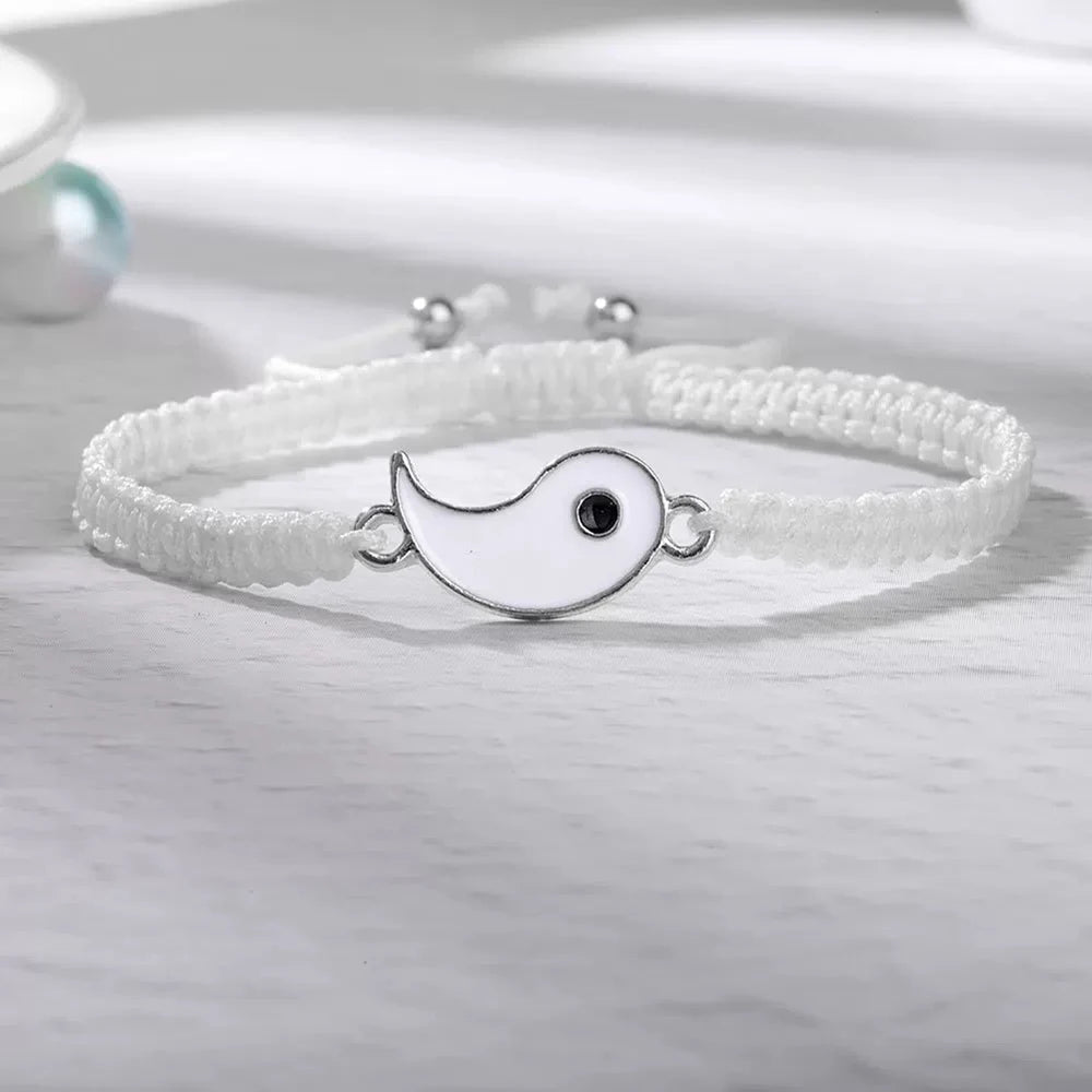 White braided bracelet featuring a Yin Yang enamel charm with a black dot, crafted from high-density nylon with adjustable closure.