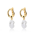 Chunky gold huggie earrings with a white enamel heart drop, showcasing a modern minimalist design.