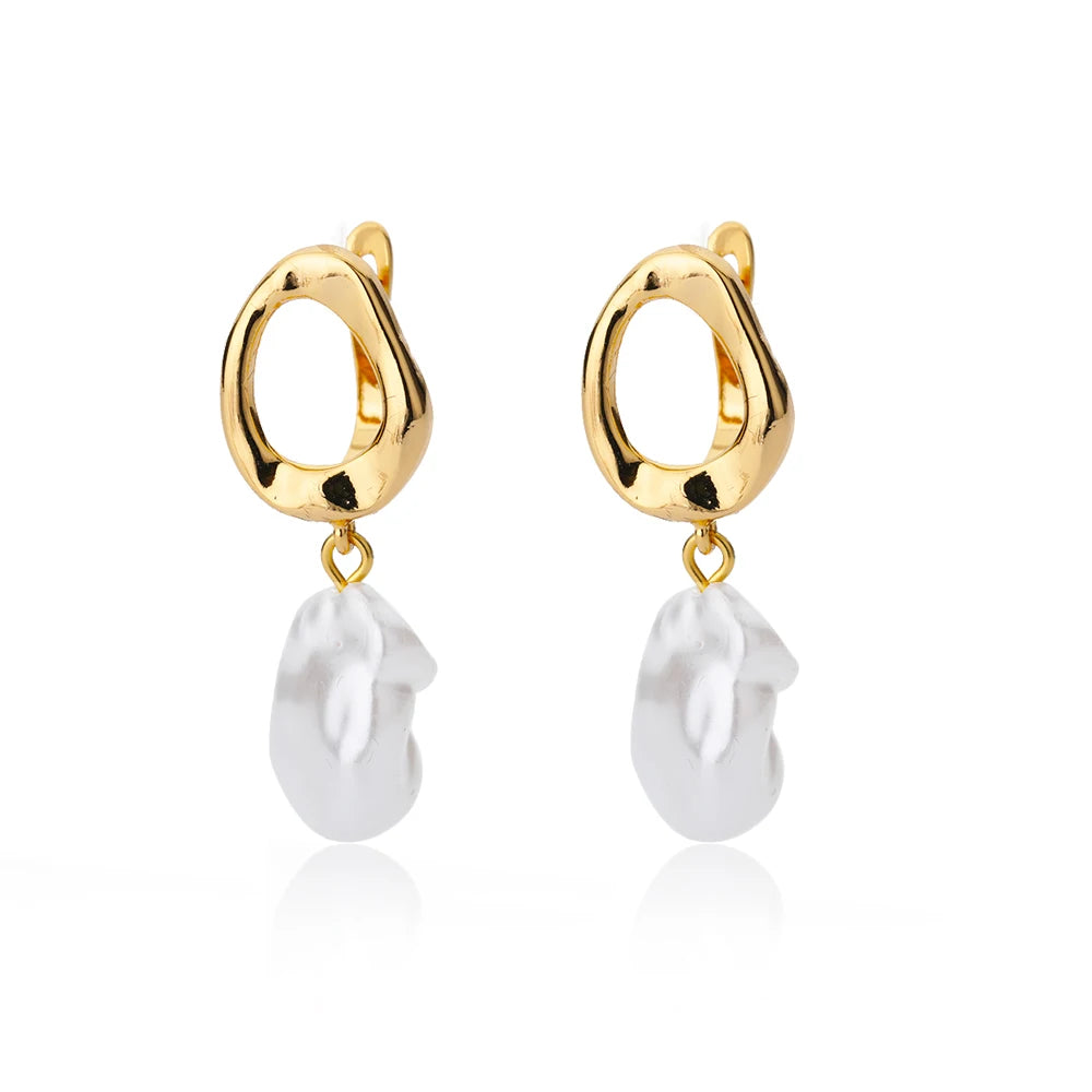 Chunky gold huggie earrings with a white enamel heart drop, showcasing a modern minimalist design.