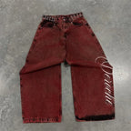 Baggy distressed denim jeans in a deep burgundy color with oversized wide legs and embroidered lettering on the side.