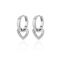 Chunky huggie earrings featuring a dropped heart design with enamel and shimmering accents in a polished silver finish.