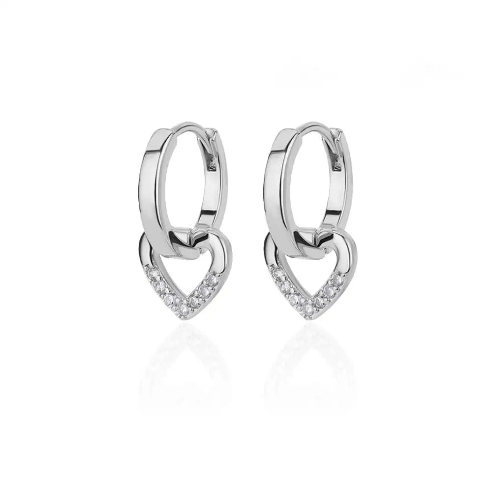 Chunky huggie earrings featuring a dropped heart design with enamel and shimmering accents in a polished silver finish.