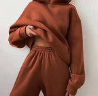 Rust-colored high-waisted tracksuit set featuring an oversized pullover hoodie and matching jogger pants.